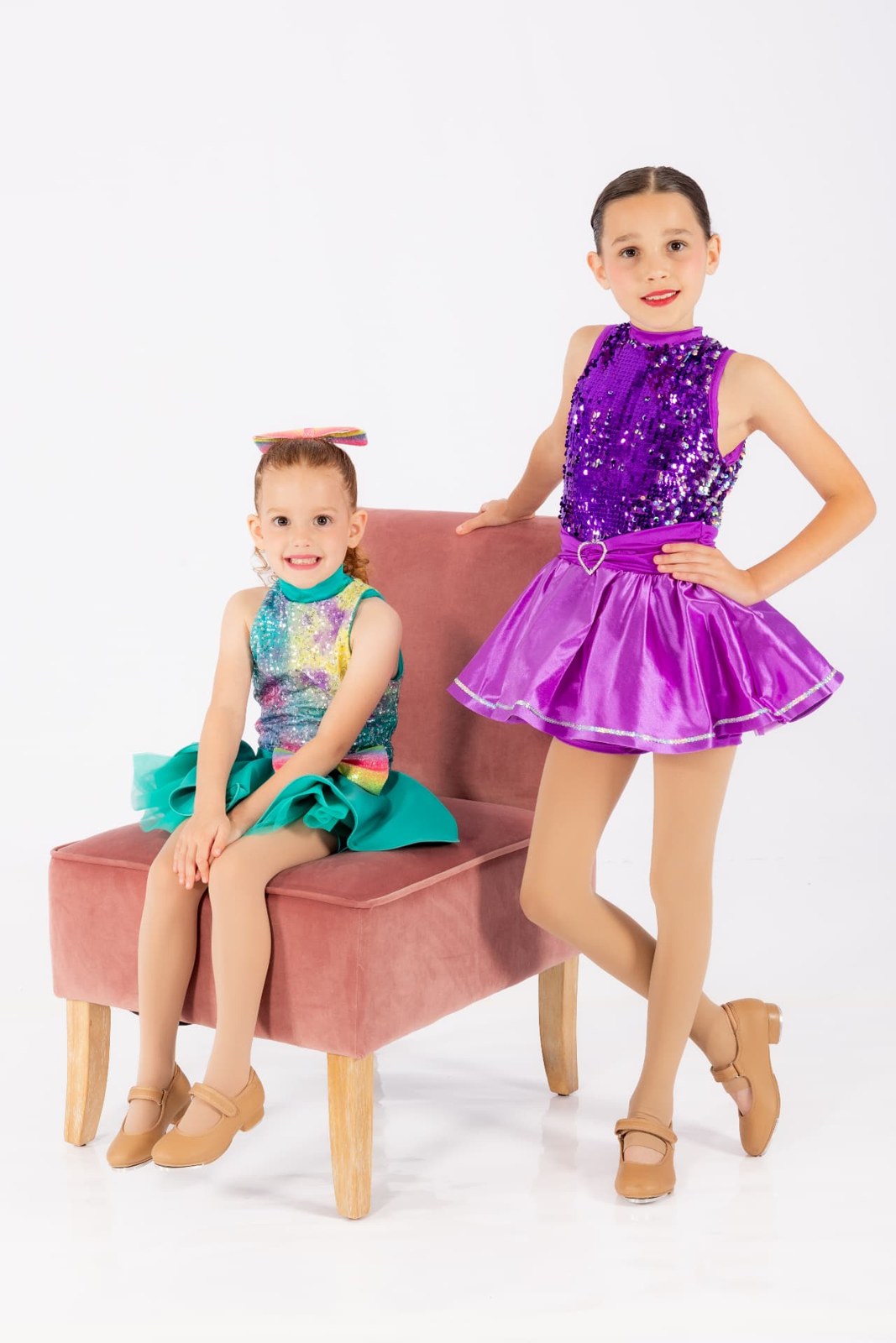 Two dancers together in teal and purple costumes