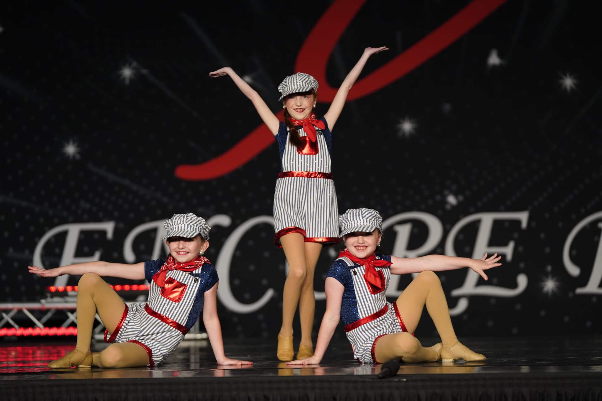Three Music in Motion dancers performing together on stage