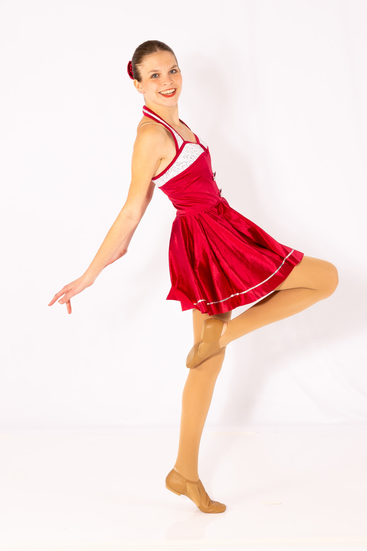 A Music in Motion dancer in a red jazz costume posing on relevé