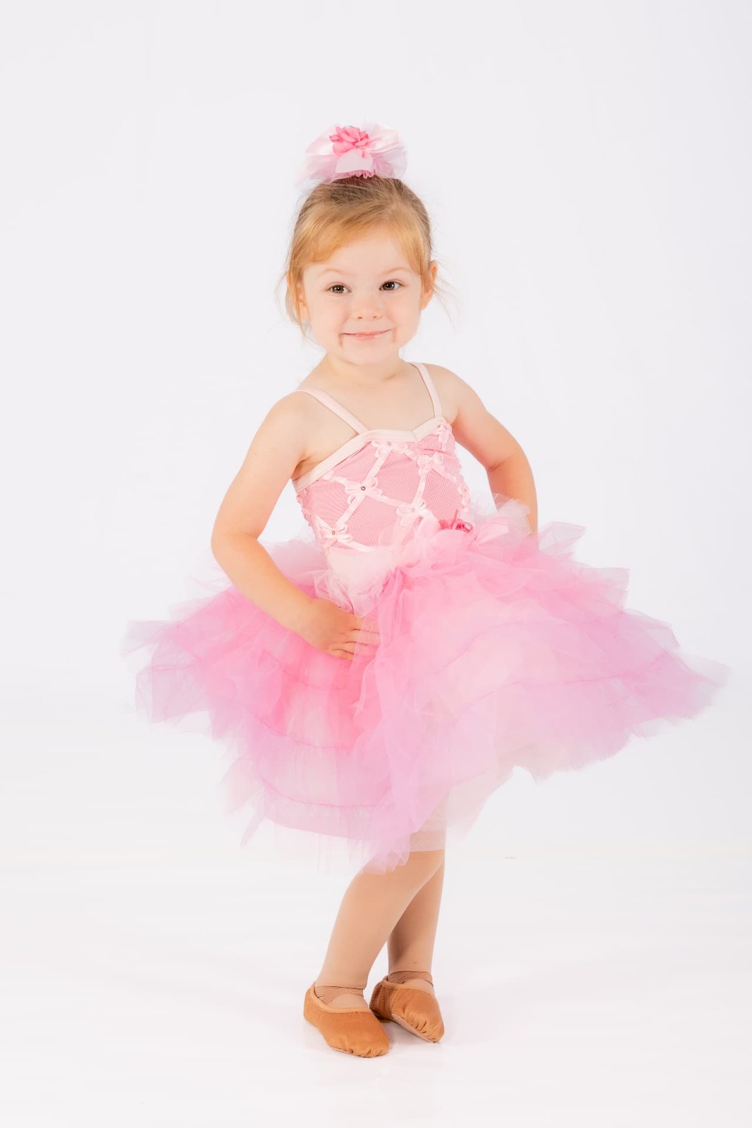 A young dancer in a pink tutu posing in the studio