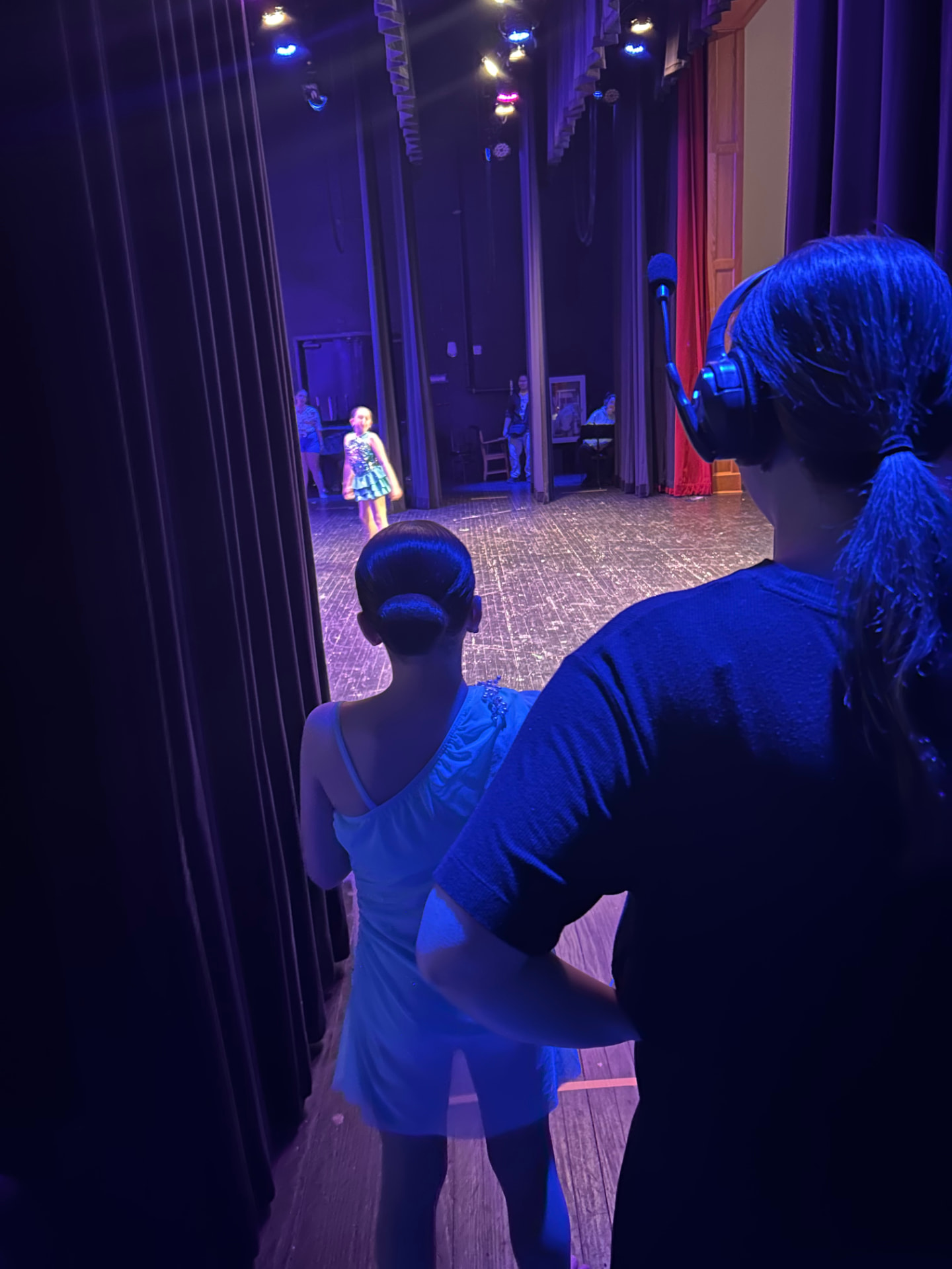 A Music in Motion staff member helping a dancer backstage