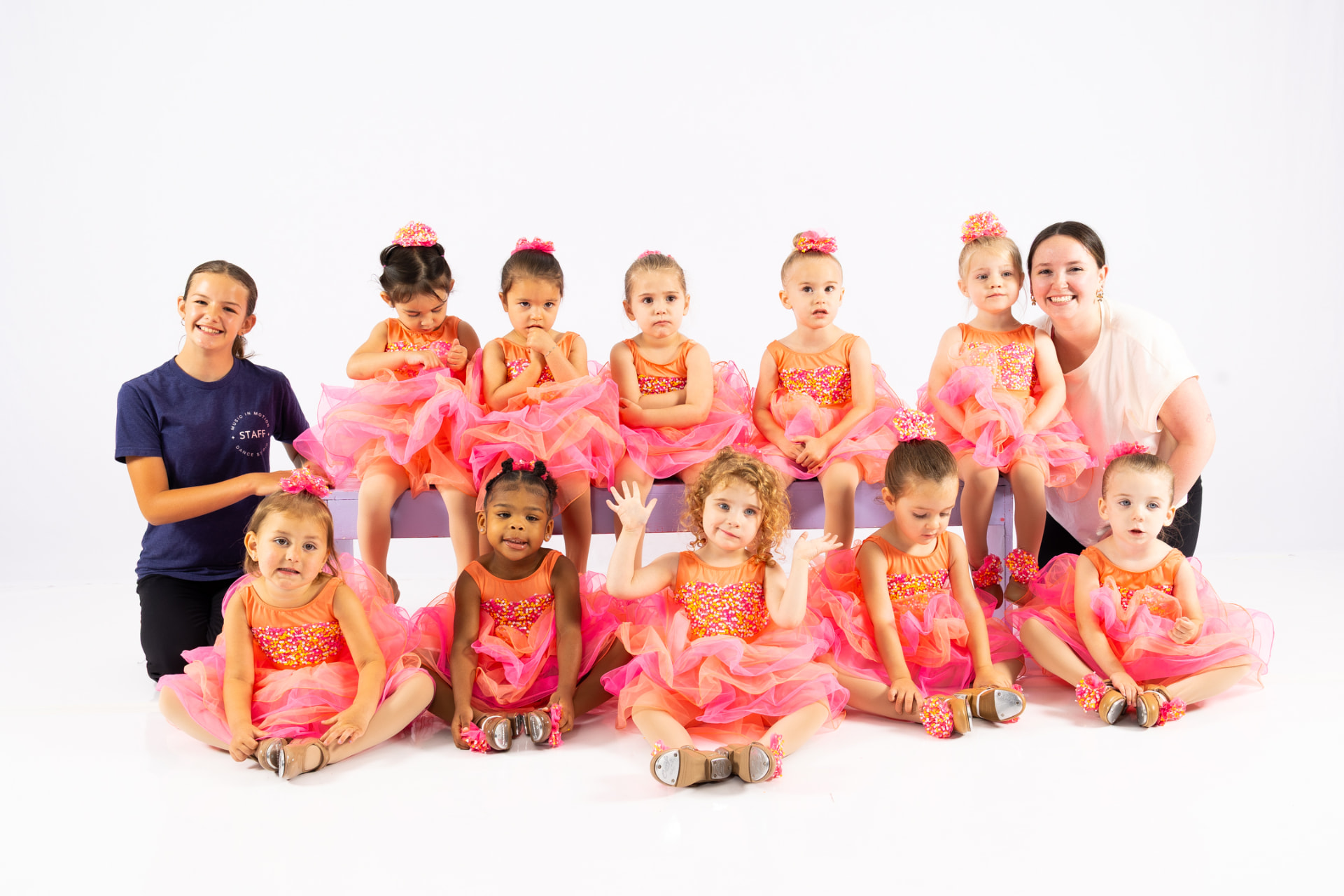 A Music in Motion toddler class in coral costumes with their teachers