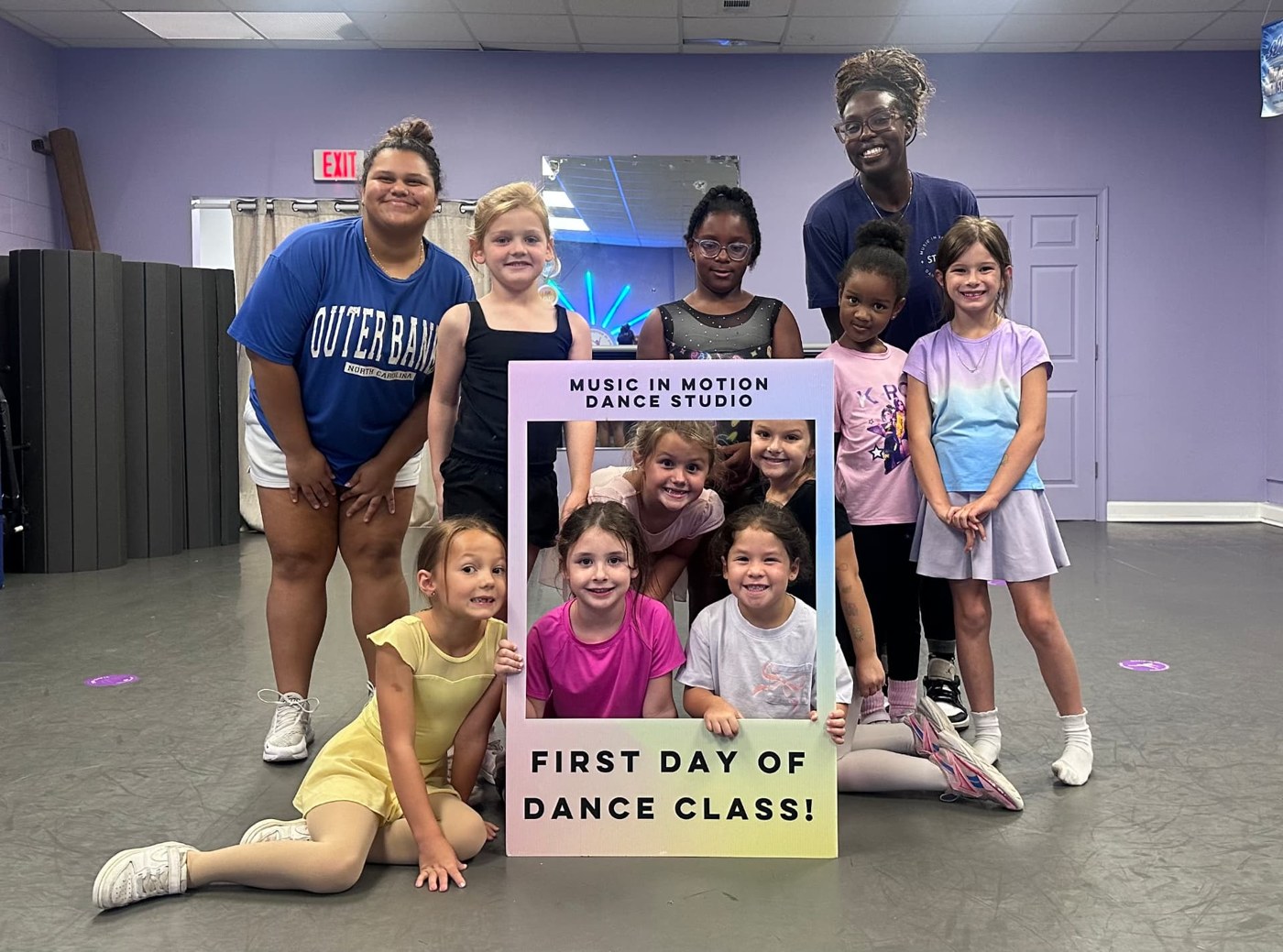 Dancers and teachers smiling with a first day of dance class frame