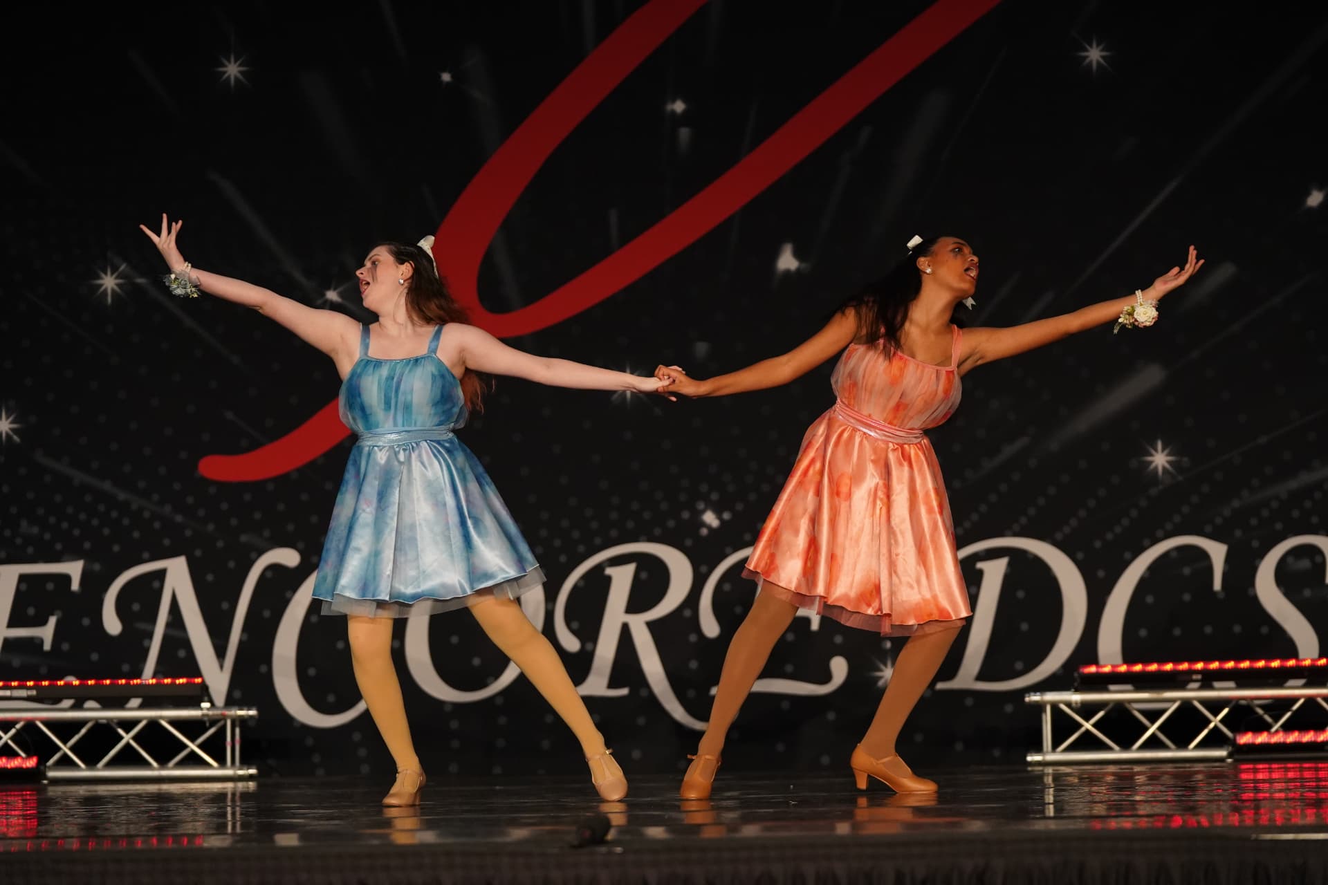 Two Music in Motion dancers performing together on stage