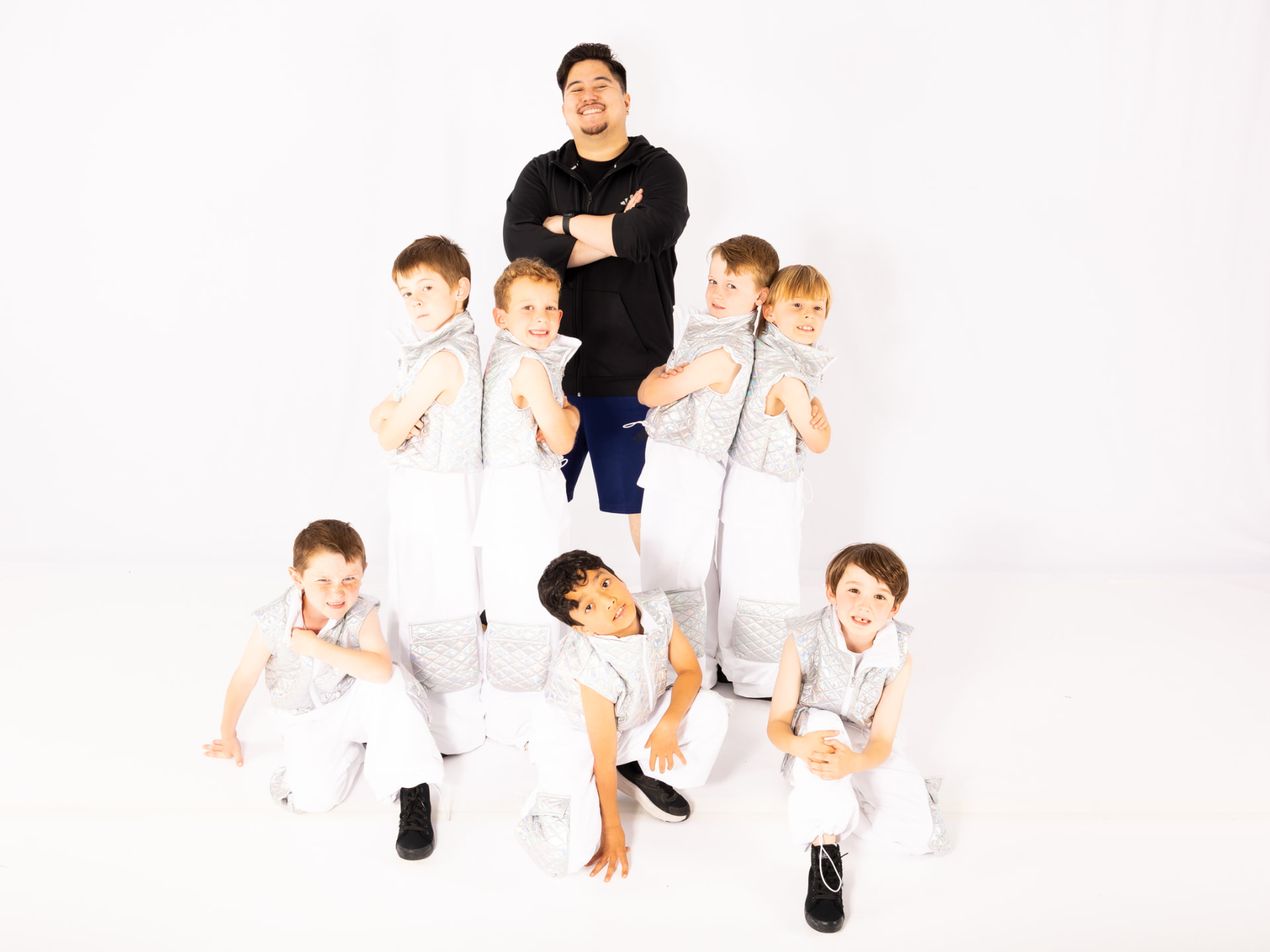 Seven boys and their teacher in silver hip hop costumes