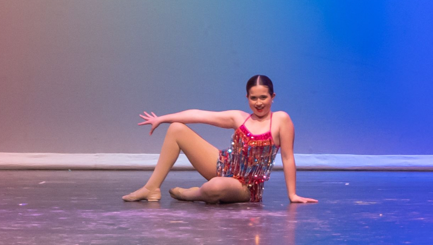 A Music in Motion dancer performing on stage in costume