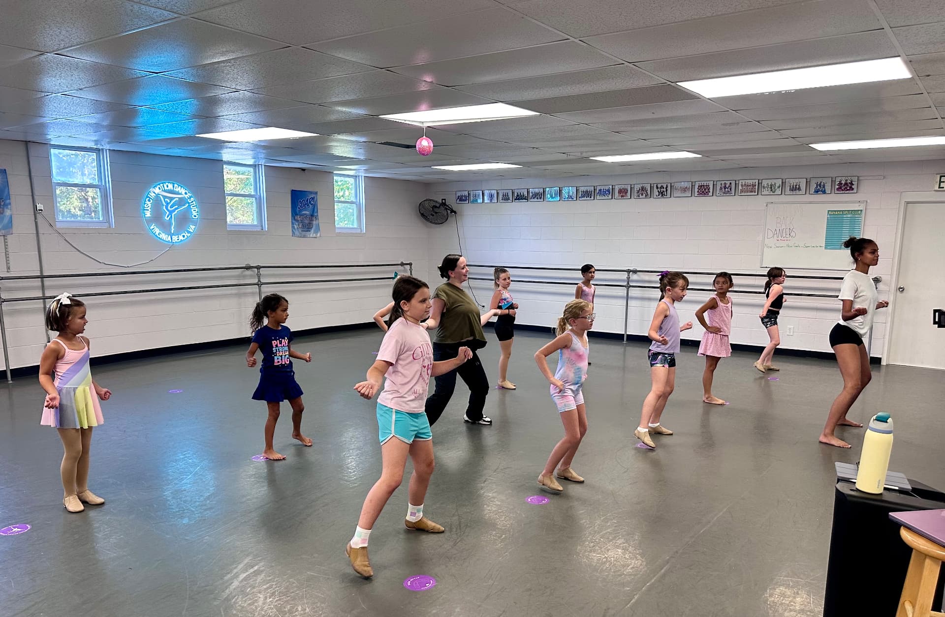 Older students dancing across the studio floor with their teacher during jazz class