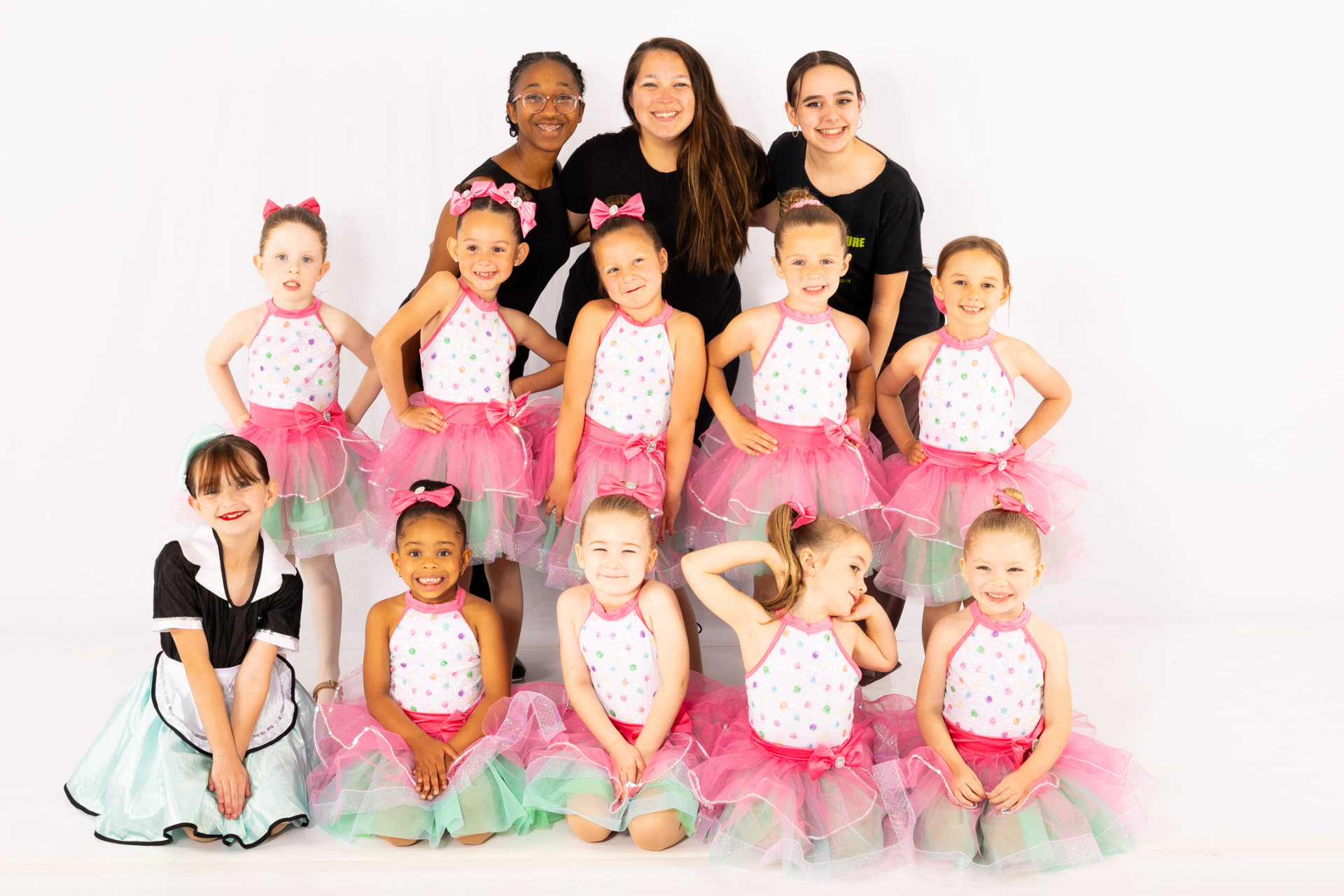 Music in Motion teacher Jess with her TBT class posing together in the studio